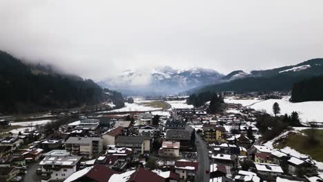 Misty-weather-over-Kirchberg-township-in-Austria,-aerial-drone-view