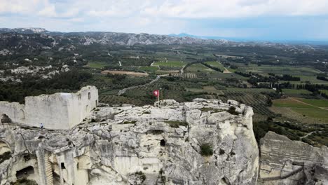 Luftaufnahme-Von-Les-Beaux-De-Provence-Mit-Einer-Im-Wind-Wehenden-Flagge