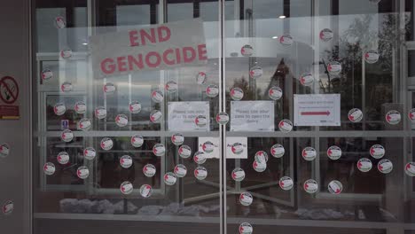 A-shot-of-small,-circular-Pro-Palestine-stickers-on-the-front-door-of-the-Scotland-BBC-headquarters
