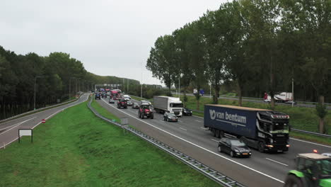 Dutch-farmers-protesting-with-their-tractors-on-the-highway,-creating-traffic-jam,-aerial-shot-rising-4K