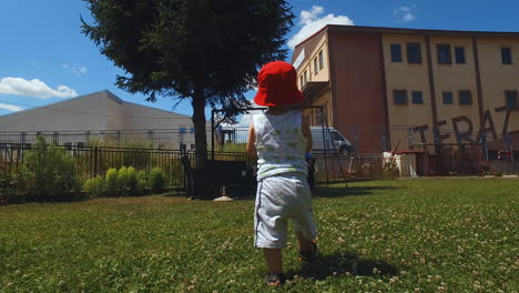 Following-Two-Year-Old-Boy-Walking-in-Backyard-With-Plastic-Bottle