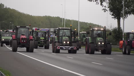 Parade-of-tractors-driving-side-by-side-on-highway-causing-slow-traffic-jam-in-protest-of-new-policies