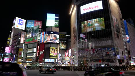 Weit-Geöffnete-Aufnahme-Des-Berühmten-Shibuya-Gedränges-In-Tokio-Während-Der-Nacht-Mit-Verkehr