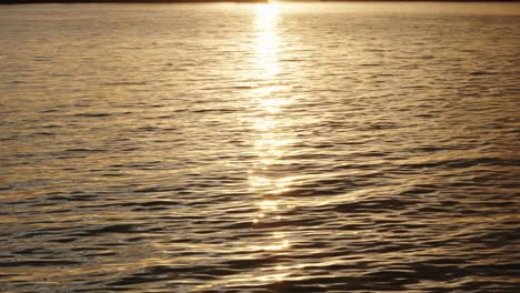Slow-mo-of-water-at-sunset-with-sun-reflecting