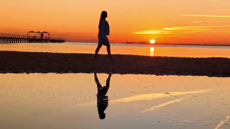 Frau-Zu-Fuß-Am-Strand-Entlang-Mit-Sonnenaufgang-Am-Morgen-In-Der-Silhouette-Im-Pickalbatros-Laguna-Vista-Hotel,-Sharm-El-Sheikh,-Ägypten