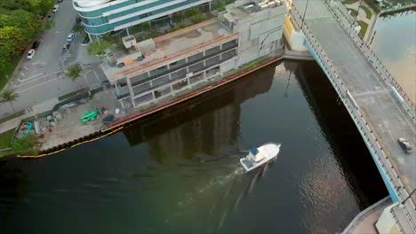 Toma-Aérea-De-Un-Barco-Pasando-Por-Debajo-De-Un-Puente-En-Miami.