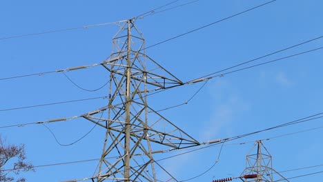 Electricity-pylon-and-wires-against-a-blue-sky