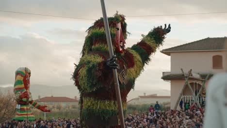 La-Efigie-Mascarada-Espera-La-Llama,-Los-Espectadores-Del-Carnaval-De-Podencia-Se-Reúnen