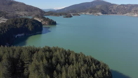 Vista-Aérea-Inclinada-Hacia-Arriba-Aoos-Spring-Lake-Metsovo-Grecia-Día-Soleado-Cielo-Azul