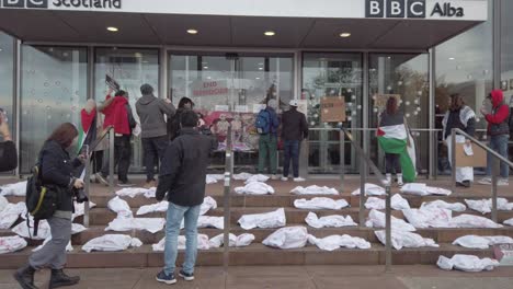 Manifestantes-Tomando-Fotografías-De-Las-Pancartas-Y-Obras-De-Arte-En-La-Puerta-Principal-De-La-Sede-De-La-BBC-En-Escocia.
