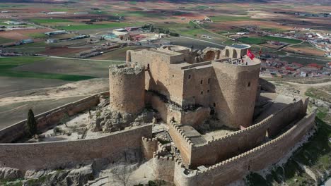 Orvital-flight-over-a-rebuilt-walled-fortress-from-the-Middle-Ages-and-with-access-to-visits-with-people-located-on-a-hill-with-good-views-and-a-background-of-population-on-a-spring-day-Toledo-Spain