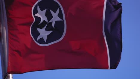 Close-up-slow-motion-footage-of-the-flag-of-Tennessee-blowing-in-the-wind-with-blue-sky-behind