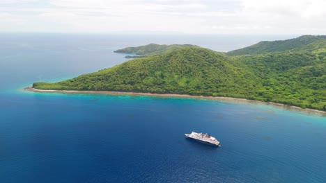 Drone-flys-around-cruise-ship-floating-off-the-coast-of-a-Fijian-island