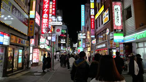 POV-walking-through-illuminated-backstreets-of-Shibuya,-Tokyo-at-night