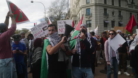 Dos-Hombres-árabes-Con-Keffiyehs-Y-Sosteniendo-Banderas-Palestinas-Gritan-Por-Un-Megáfono-En-Una-Manifestación-A-Favor-De-Palestina.