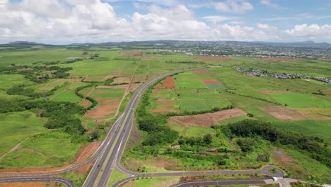 Verdun-highway-cutting-through-lush-mauritian-landscape,-sunny-day,-aerial-view