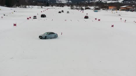 Aggressive-car-maneuver-on-snowy-race-track,-cars-in-background-approach