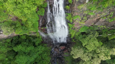 Descending-down-a-rushing-waterfall-running-deep-into-a-tropical-rainforest-tourist-attraction