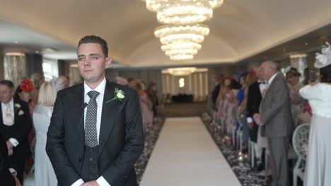 Guests-and-nervous-groom-waiting-at-the-aisle-for-bride-to-be-to-arrive