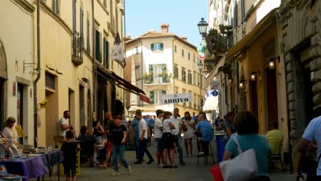 Die-Eingangsstraße-Des-Spanferkelfestes-Von-Monte-San-Savino-In-Italien-Mit-Herumlaufenden-Kindern-Und-Zu-Fuß-Gehenden-Touristen