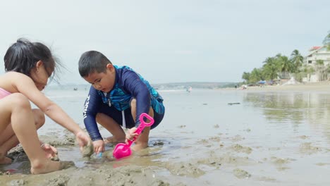 Zwei-Asiatische-Kinder-Spielen-Im-Sand-An-Einem-Wunderschönen-Strand
