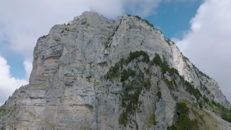 Tilt-up-to-summit-rock's-mountain-with-clouds,-Mount-Granier,-French-Alps