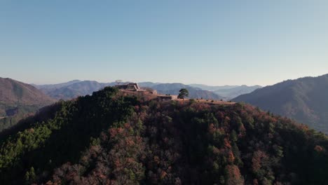 Cima-De-La-Montaña-Verde-De-Las-Antiguas-Ruinas-Del-Castillo-De-Takeda-Horizonte-Japonés-Vista-Aérea-De-Drones-Sobre-La-Antigua-Fortaleza