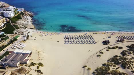 Playa-De-Cala-Mesquida-Con-Aguas-Cristalinas-Y-Bañistas,-Brillante-Día-De-Verano,-Vista-Aérea