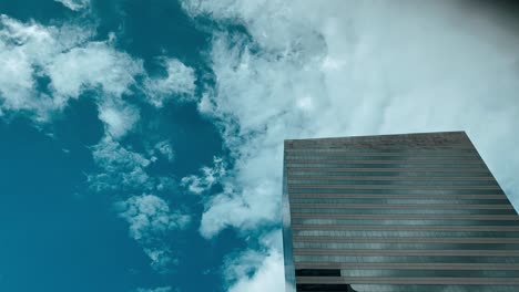 Gespiegeltes-Gebäude-Mit-Schnell-Vorbeiziehenden-Wolken