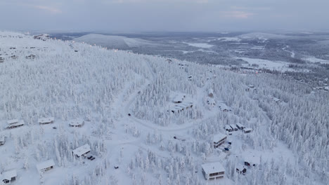 Drone-shot-of-cabins-and-traffic-on-a-fell,-gloomy-winter-day-in-Lapland