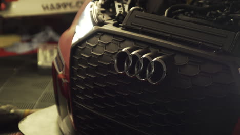 Audi-race-car-in-mechanic-shop-with-its-headlights-on