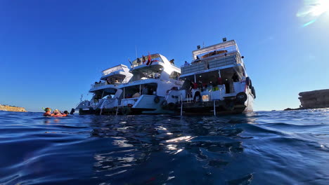 Yachts-anchored-in-clear-blue-water-near-Sharm-El-Sheikh,-Egypt,-under-sunny-skies