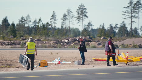 Model-aircraft-pilots-walking-towards-their-airplanes-at-small-airfield