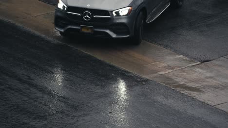 Mercedes-Car-Moving-on-Wet-Street-During-Rainy-Day-in-Downtown-Los-Angeles,-California-USA,-Slow-Motion