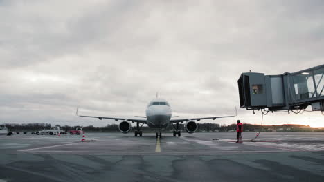 Airplane-Airbus-A320-pulling-into-parking-space-and-with-aircraft-marshaling-from-ground-crew
