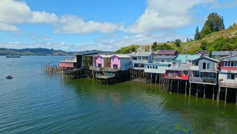 Stilt-houses-of-Castro-in-Chiloe,-colorful-houses-on-the-water-dolly-out,-Chile