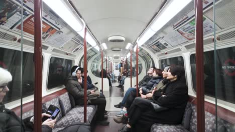 Los-Pasajeros-Están-Sentados-A-Bordo-De-Un-Tren-De-Metro-De-La-Línea-Bakerloo-En-El-Metro-De-Londres,-Lo-Que-Ilustra-El-Concepto-De-Desplazamiento-Urbano-Y-Eficiencia-Del-Transporte-Público.