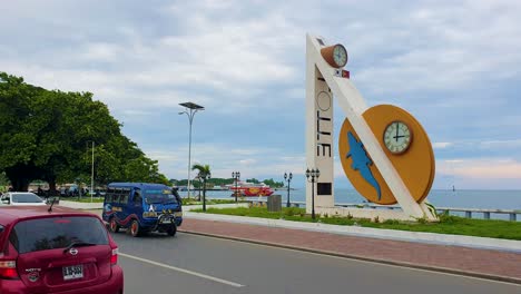 Inner-city-street-view-of-waterfront,-traffic-and-clock-landmark-connecting-South-Korea-and-Timor-Leste-in-the-capital-city-of-East-Timor,-Southeast-Asia