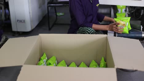 pov-shot-slow-motion-seen-man-picking-up-the-packet-of-chips-and-arranging-them-in-the-box