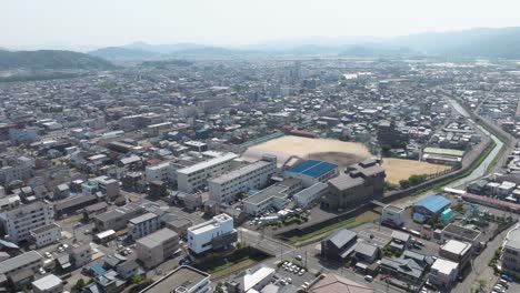 Aerial-Drone-Fly-Above-Fukui-City-in-Japan-Downtown,-Mountains-Cityscape-Skyline-in-Summer,-Japanese-Prefecture