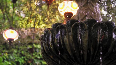 Schöner-Brunnen,-Austretendes-Wasser-Mit-Schöner-Hintergrundbeleuchtung-In-Der-Umgebung-Eines-Gartens-Im-Freien