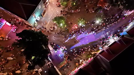 High-fashion-show-with-models-walking-streets-of-Kura-Hulanda-village-in-Otrobanda-Willemstad-Curacao-at-night,-aerial-bird's-eye-view