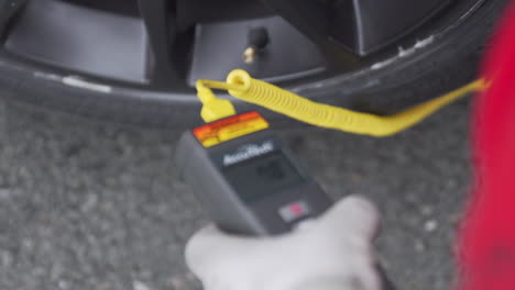 Mechanic-Measuring-Tire-Temperature-With-A-Handheld-Device