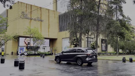 Cars-and-people-walk-by-Palacio-de-Hierro-in-Polanco-on-a-rainy-day-in-Mexico-City