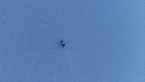 Isolated-car-turning-in-circles-on-white-surface-of-Bonneville-Salt-Flats,-Utah