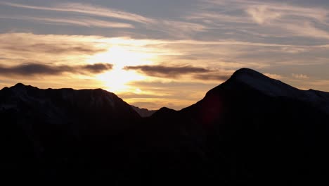 Gegenlichtbeleuchtete-Silhouette-Der-Agrafa-Berge-In-Griechenland,-Während-Die-Sonne-Hell-Vor-Dünnen-Wolken-Scheint