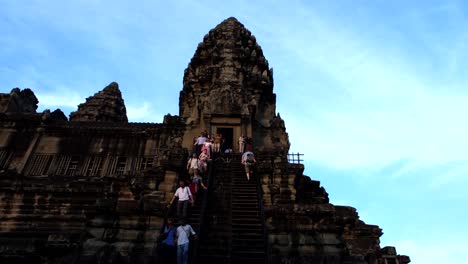 Angkor-Wats-Hoch-Aufragende-Struktur-Verfügt-über-Lange-Treppen,-Die-Den-Auf--Und-Abstieg-Der-Touristen-Erleichtern,-Die-Die-Stufen-Hinaufsteigen-Und-Das-Historische-Wunder-Inmitten-Des-Geschäftigen-Treibens-Erkunden.