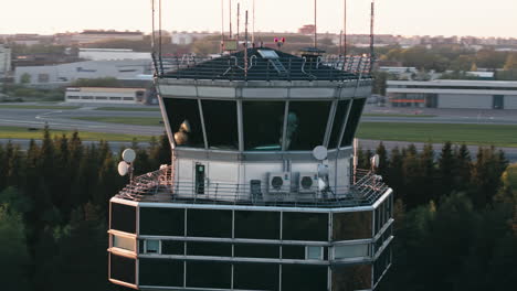 Panorámica-Alrededor-De-La-Torre-De-Control-Del-Tráfico-Aéreo-Del-Aeropuerto-De-Tallin-Con-Pista-Y-Delantales-En-Segundo-Plano.