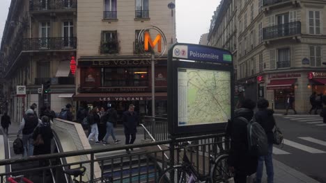 Slomo-De-Gente-Moviéndose-Por-Las-Calles-De-París-En-Metro-Poissonière,-Mujer-Comprueba-El-Mapa