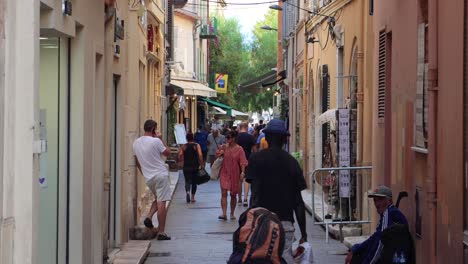 Menschen-Gehen-Auf-Einer-Schmalen-Fußgängerzone-In-Der-Altstadt-Von-Antibes,-Frankreich